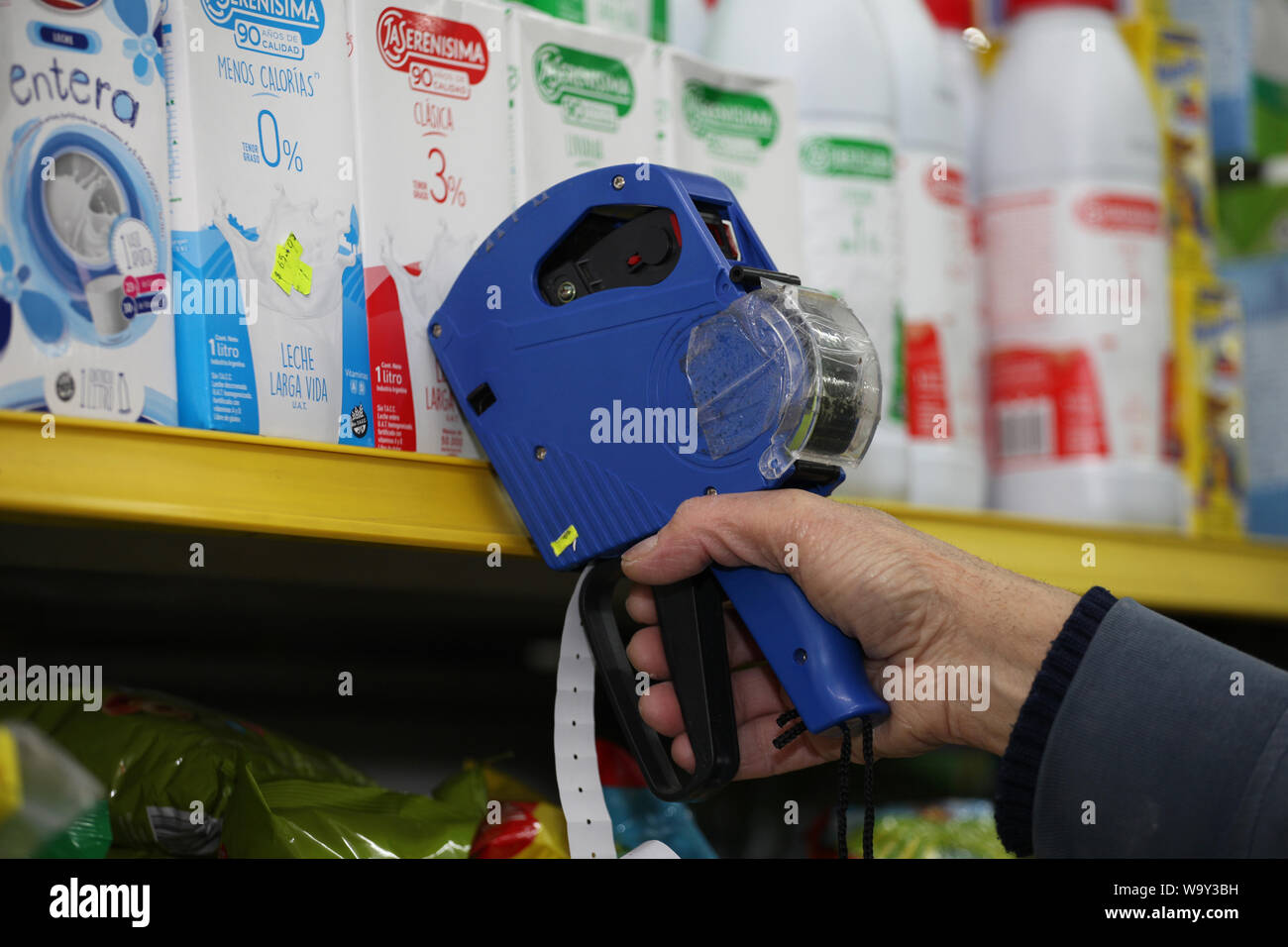 Buenos Aires, Argentina. 14 Ago, 2019. Un dipendente segni di confezioni di latte con i nuovi prezzi dopo questa settimana di turbolenze economiche. I mercati azionari in Buenos Aires sono crollati in seguito alla sconfitta elettorale per il Presidente Macri liberale di governo nelle elezioni primarie. Il principale indice S&P Merval ha perso il 35,5 percento. Il peso argentino ha anche fatto irruzione in. Come risultato, i prezzi sono aumentati in diversi settori. In Argentina si trova in una grave recessione, con il 10,1 per cento di disoccupazione e di oltre il 50 percento di inflazione. Credito: Claudio Santisteban/dpa/Alamy Live News Foto Stock