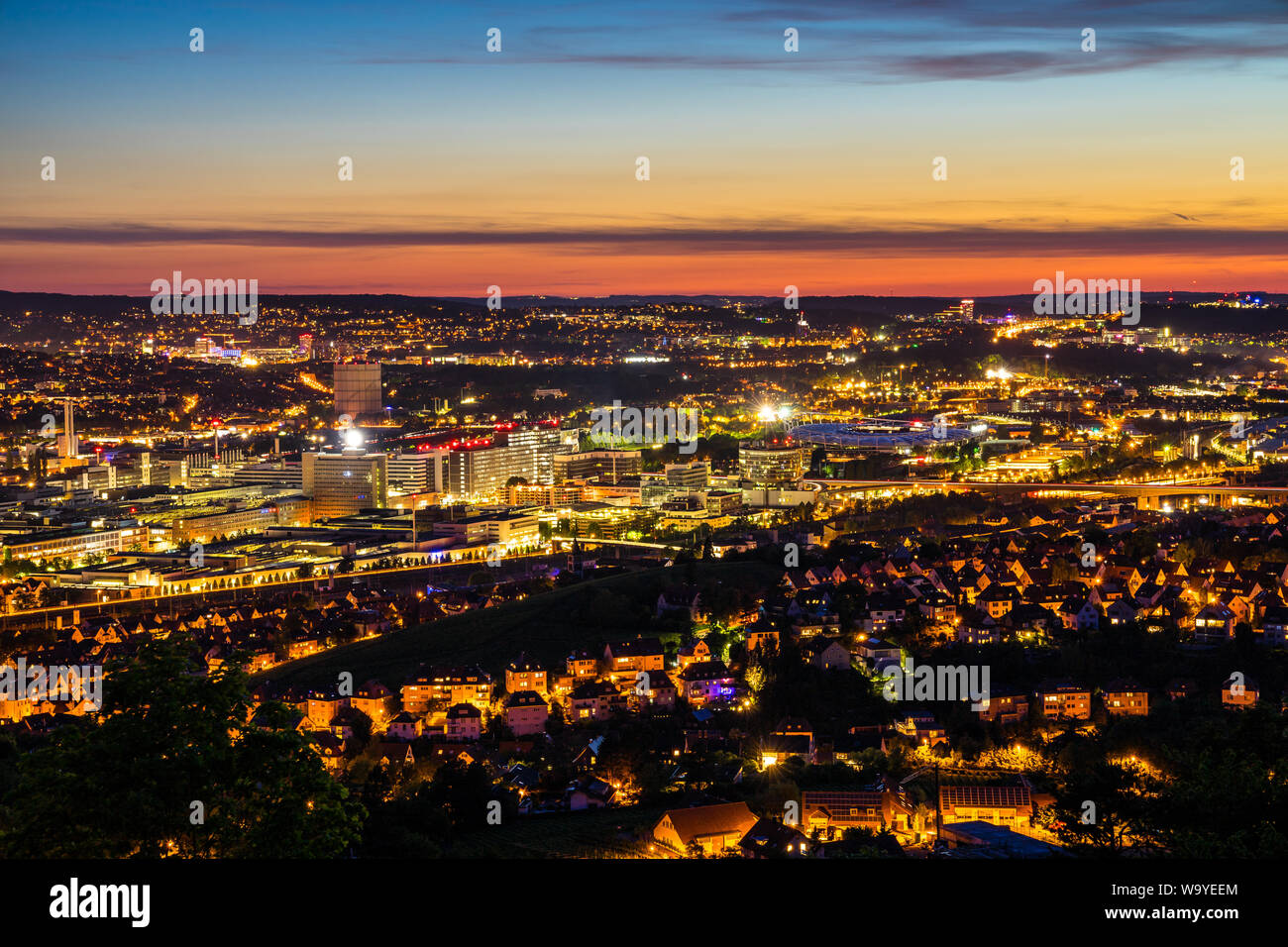 In Germania, di notte le luci del famoso quartiere urbano bad canstatt stadium del centro della città di Stoccarda nella magica atmosfera di crepuscolo Foto Stock