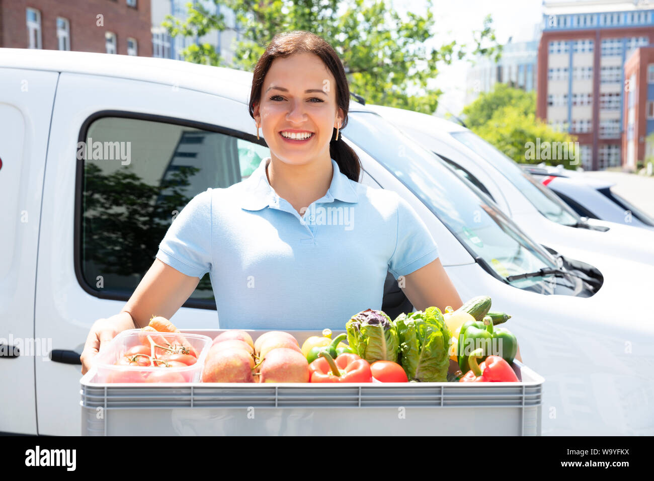 Donna felice Azienda negozio di generi alimentari Shopping Basket con verdure Foto Stock
