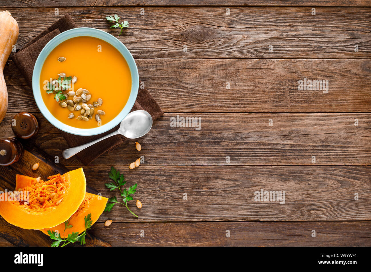 Zuppa di zucca. Zuppa vegetariana con i semi di zucca nella ciotola sul tavolo di legno, vista dall'alto Foto Stock