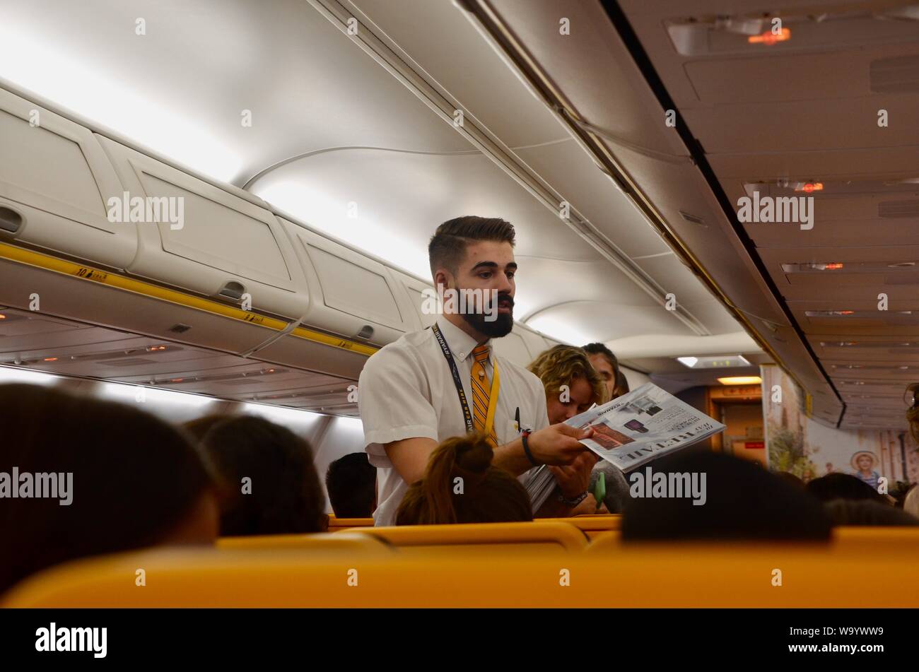 Interno di un volo Ryanair con equipaggio di cabina distribuivano inflight magazine Foto Stock