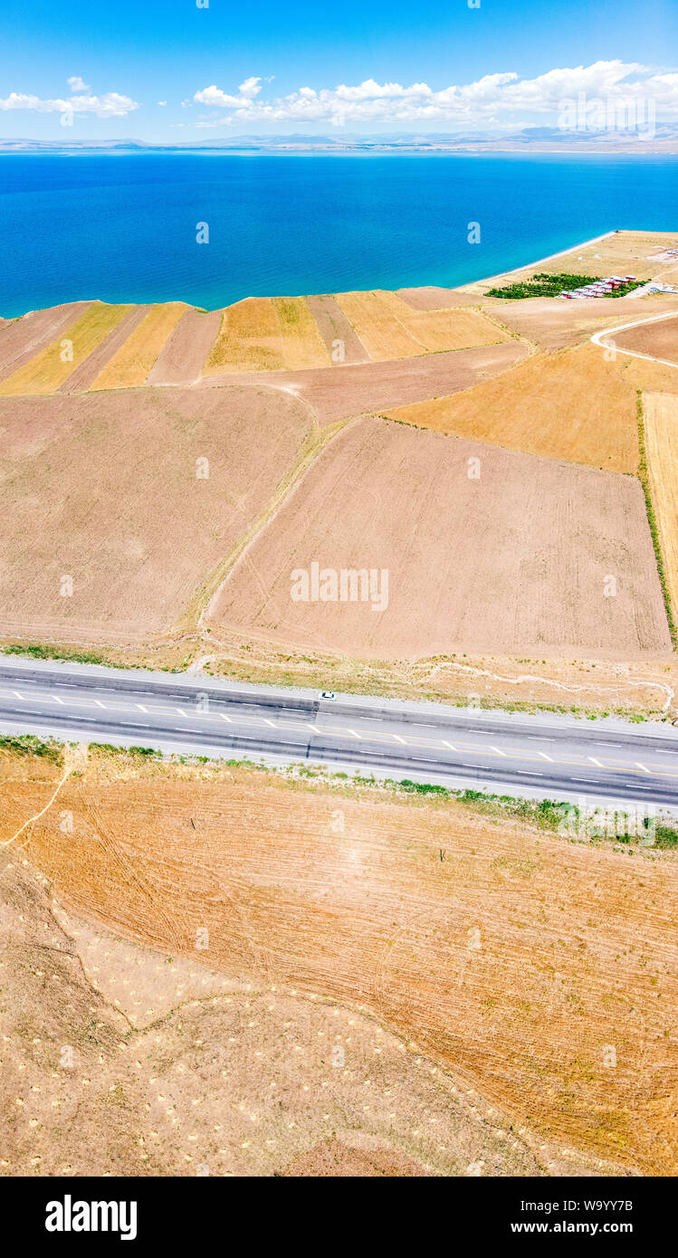 Vista aerea del lago di Van il lago più grande in Turchia, campi e scogliere che si affaccia sulle acque cristalline. Strade lungo il lago Foto Stock