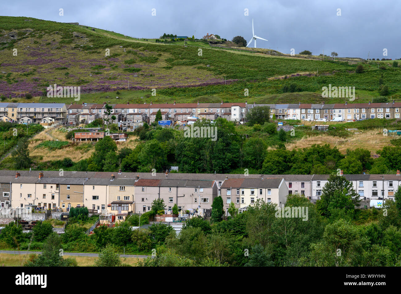 Le case a schiera di Cwmsyfiog, New Tredegar, South Wales UK si aggrappano al verde di montagna. Foto Stock