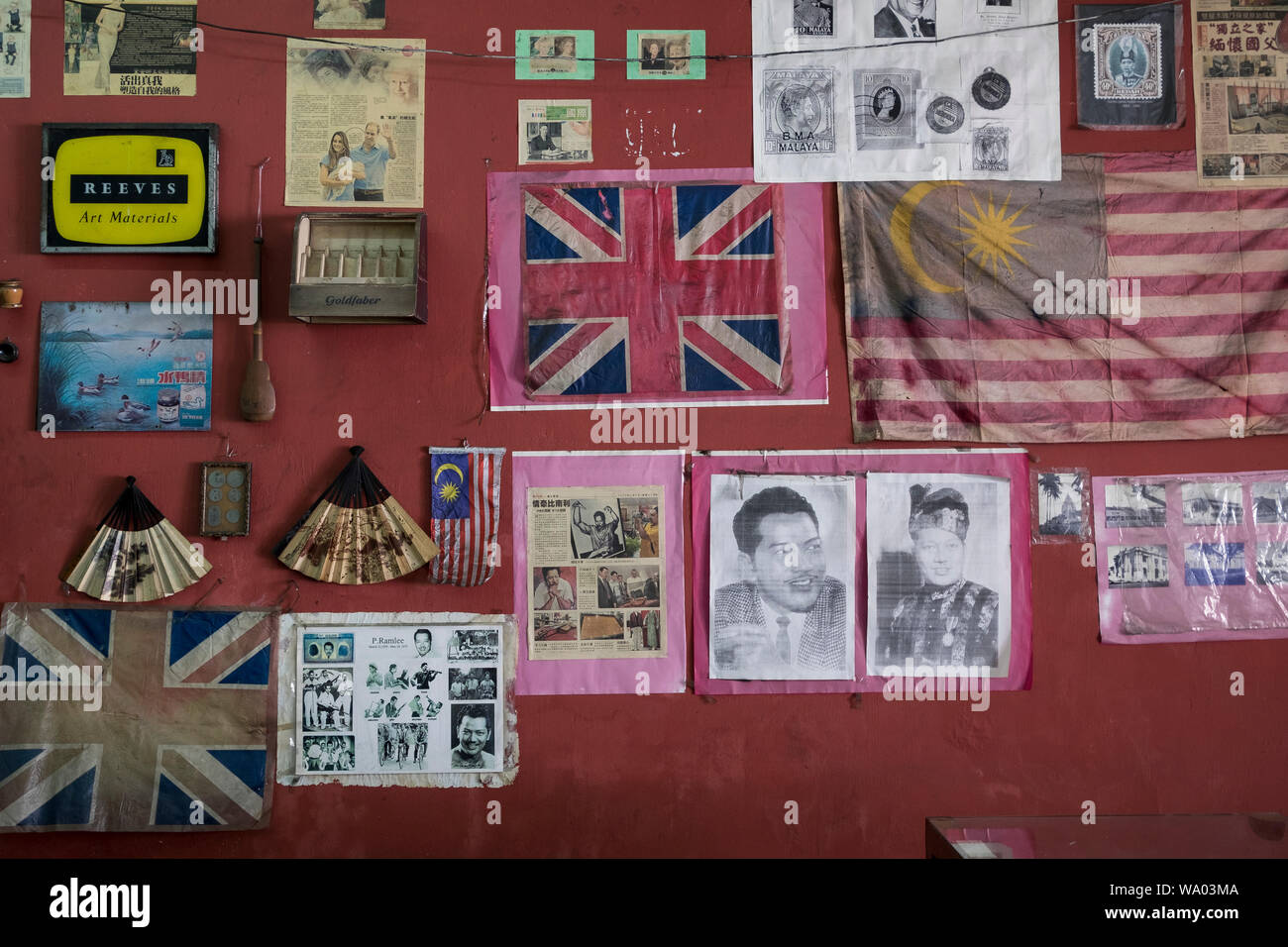 Una parete a un negozio di antiquariato in Alor Setar, Kedah, Malaysia. Le vecchie versioni del governo britannico e di bandiera malese e celebrity P Ramlee immagini sono sul wal Foto Stock