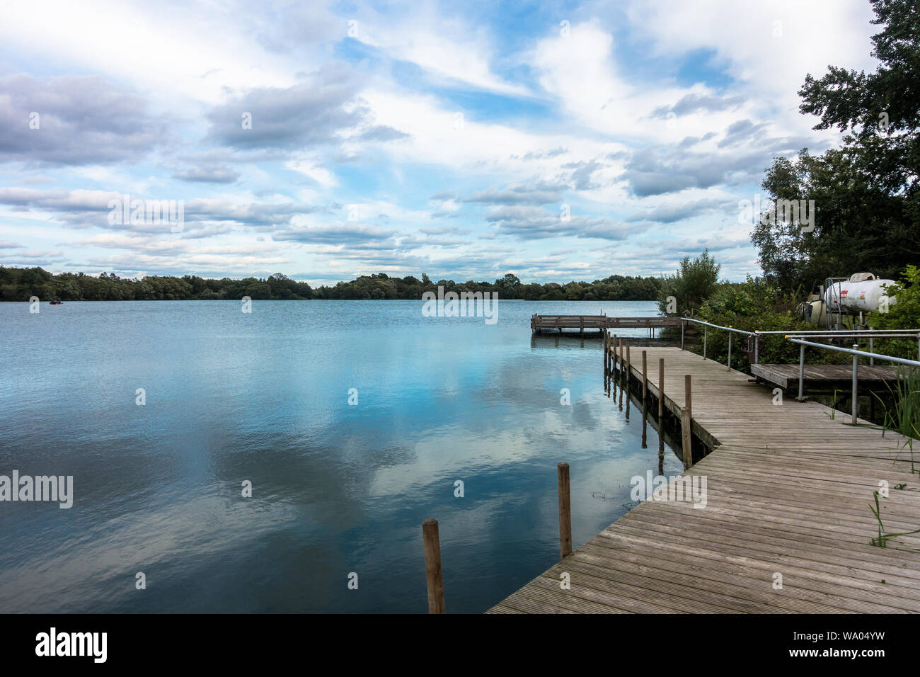 Una vista di fronte di un lago in lettura, UK. Una scena di calma con le nubi riflessi nell'acqua. Foto Stock