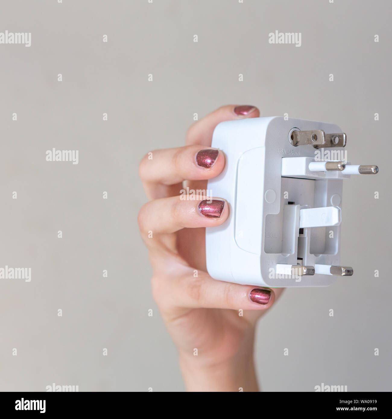 Primo piano di adattatori per prese elettriche universali da donna, isolati su sfondo bianco. Utilizzato per collegare le prese elettriche in tutto il mondo. Foto Stock