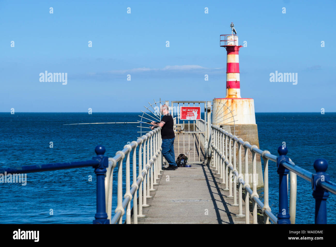 La pesca in mare da un molo. Foto Stock