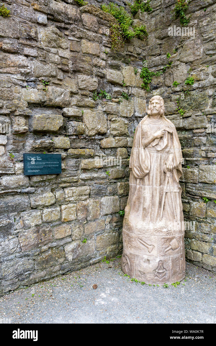 Una statua di uno dei maestri muratori responsabile per la costruzione di Beaumaris Castle, Anglesey, Galles, Regno Unito Foto Stock