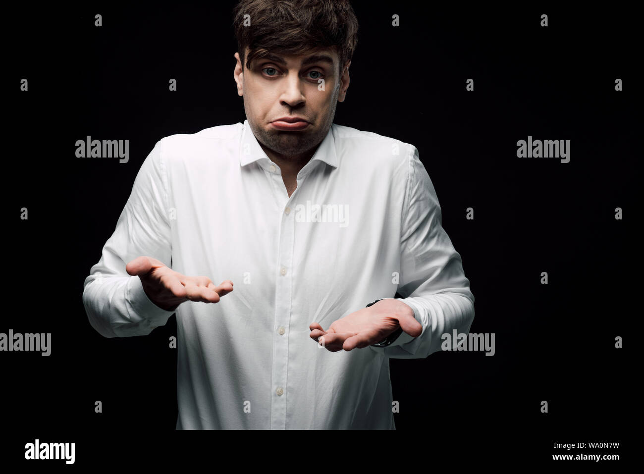 Ubriaco, sconvolto imprenditore gesticolando e smorfie in telecamera isolata sul nero, emozione umana e il concetto di espressione Foto Stock