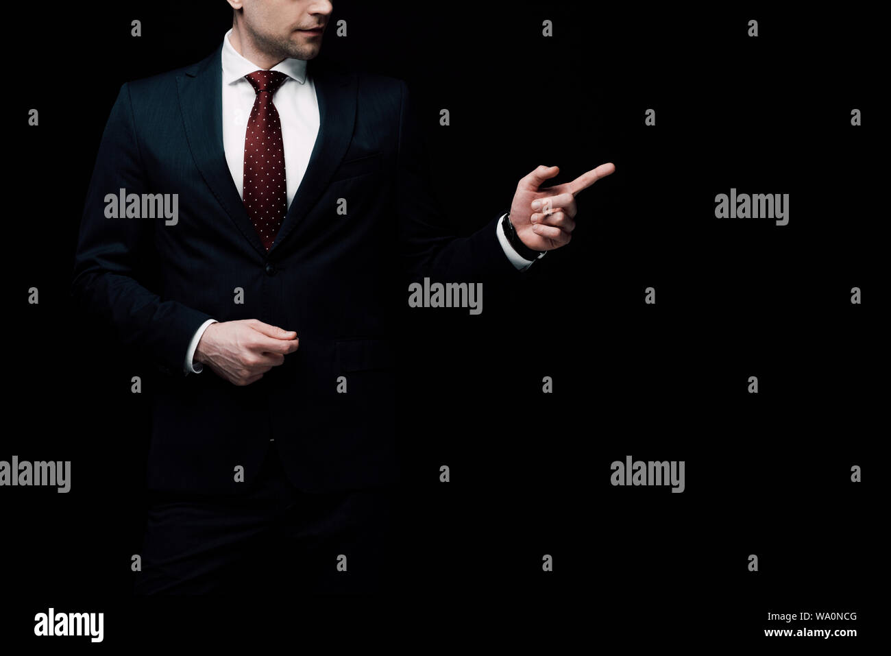 Vista parziale di imprenditore puntando con il dito isolato sul nero, emozione umana e il concetto di espressione Foto Stock