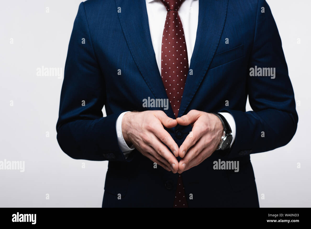 Vista parziale di imprenditore fiducioso che mostra steeple gesto isolato sul grigio, emozioni umane e concetto di espressione Foto Stock