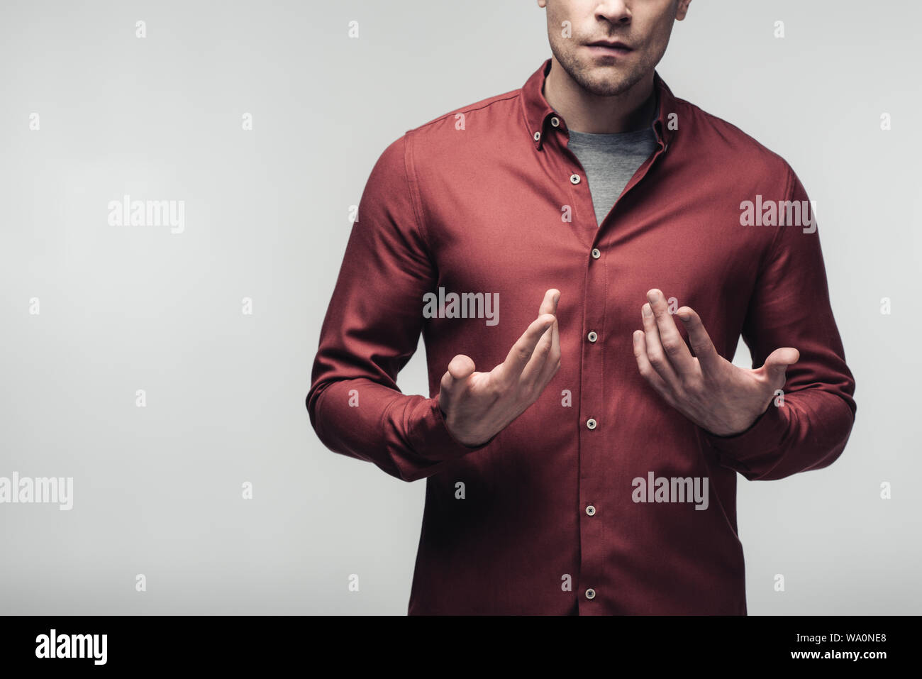 Fiducioso imprenditore usando il linguaggio del corpo e gesti con le mani isolate su grigio, emozioni umane e concetto di espressione Foto Stock