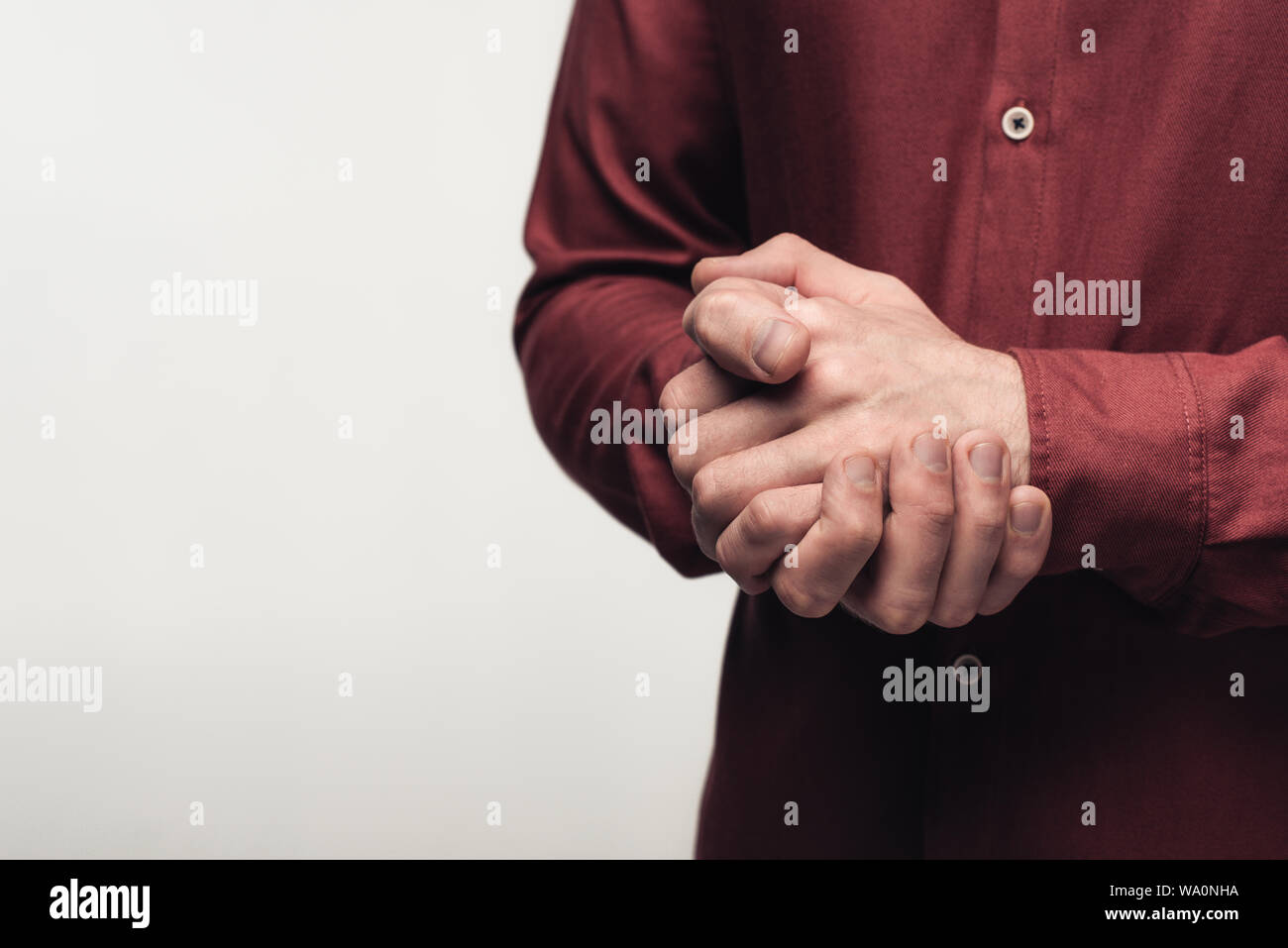 Vista parziale dell'uomo con le mani chiuse usando il linguaggio del corpo isolato sul grigio, emozioni umane e concetto di espressione Foto Stock