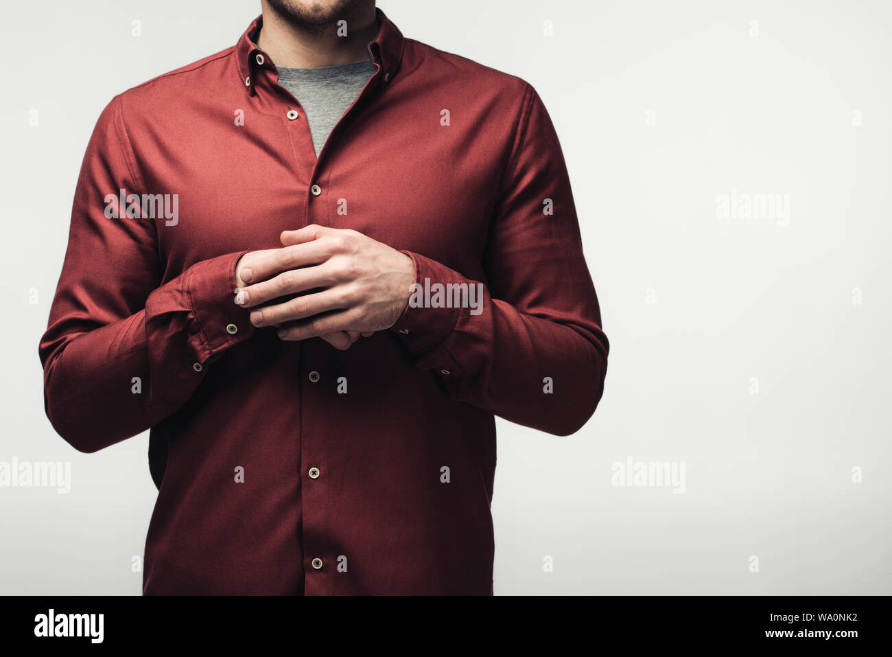 Vista parziale dell'uomo con le mani giunte isolato su grigio, emozione umana e il concetto di espressione Foto Stock