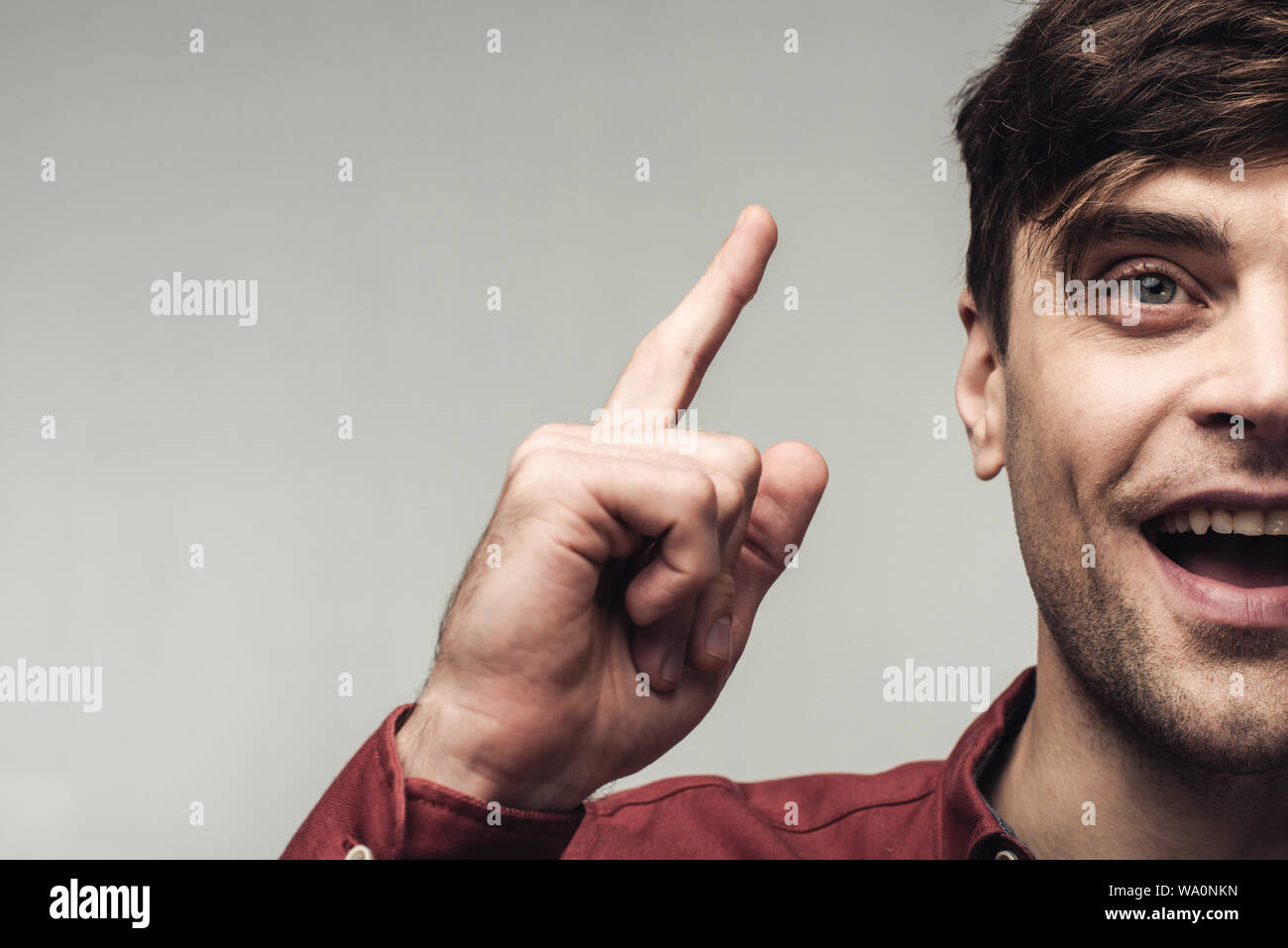 Vista ritagliata della uomo eccitato che mostra idea segno isolato sul grigio, emozioni umane e concetto di espressione Foto Stock