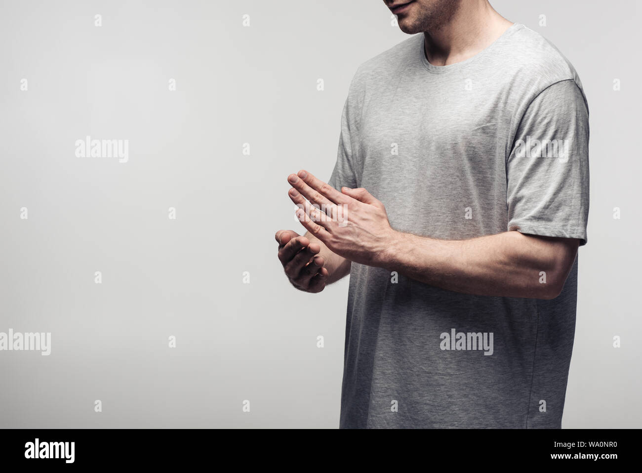 Vista parziale dell'uomo gesti con le mani mentre si utilizza il linguaggio del corpo isolato sul grigio, emozioni umane e concetto di espressione Foto Stock