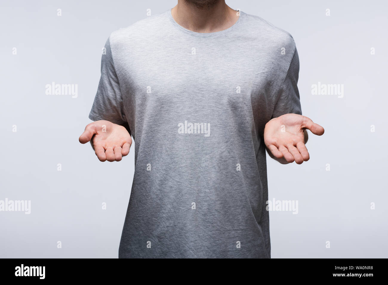 Vista ritagliata dell uomo che mostra mani aperte isolati su grigio, emozioni umane e concetto di espressione Foto Stock