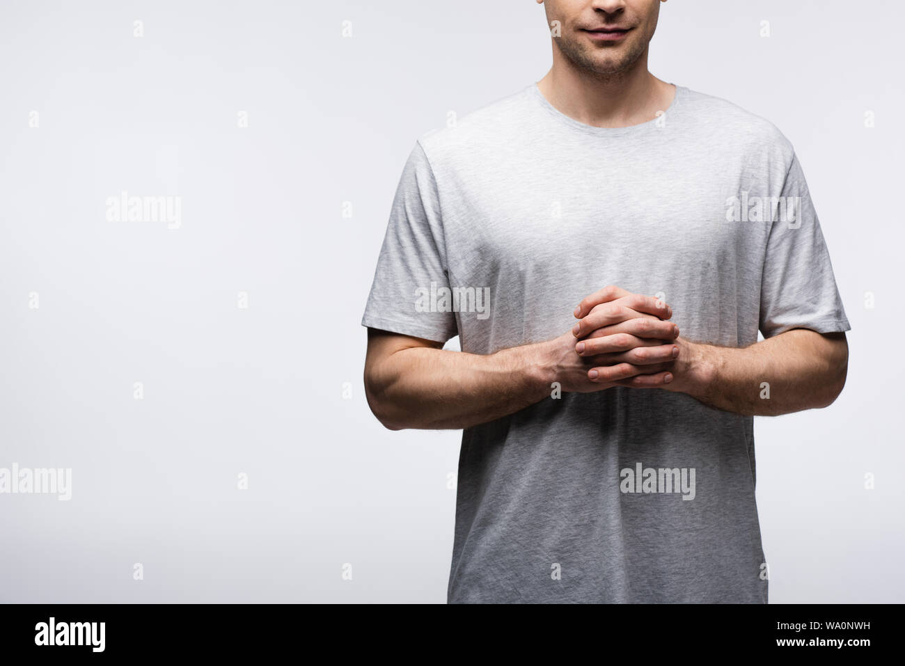 Vista parziale dell'uomo in piedi con le mani chiuse isolate su grigio, emozioni umane e concetto di espressione Foto Stock