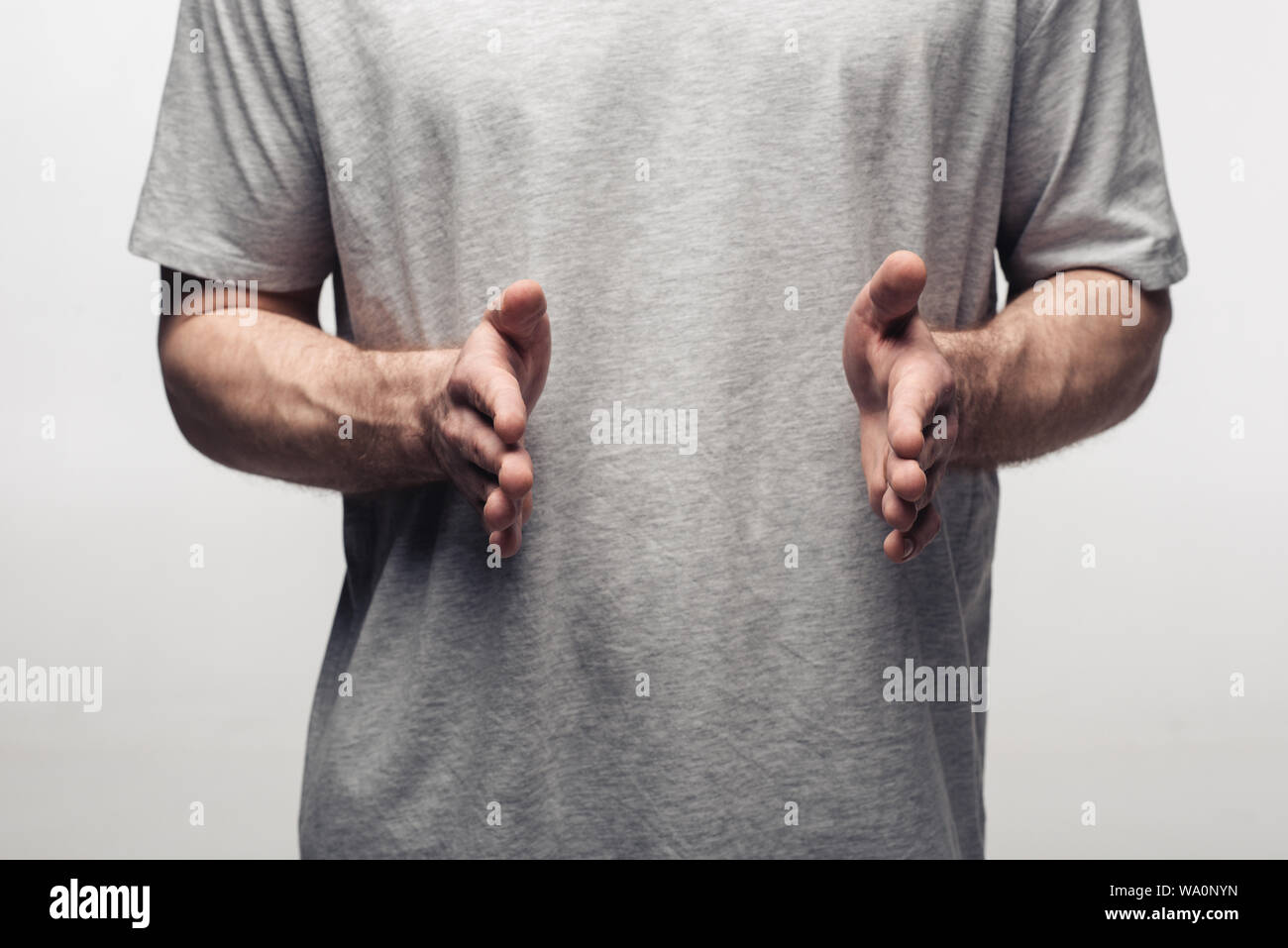 Vista parziale dell'uomo che mostra dimensioni gesto isolato sul grigio, emozioni umane e concetto di espressione Foto Stock