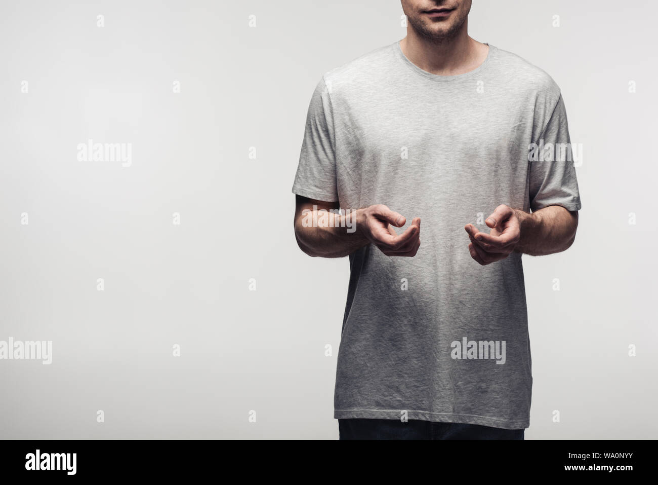 Vista ritagliata dell'uomo gesti con le mani mentre si utilizza il linguaggio del corpo isolato sul grigio, emozioni umane e concetto di espressione Foto Stock