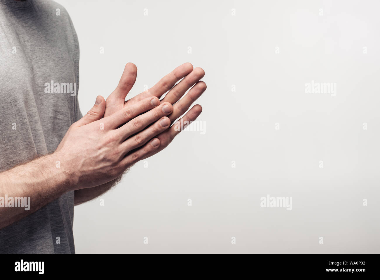Vista parziale dell'uomo strofinando le mani isolate su grigio, emozioni umane e concetto di espressione Foto Stock