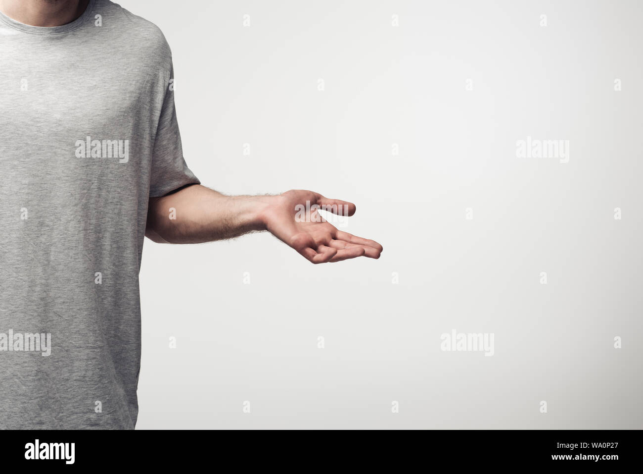 Vista ritagliata dell uomo che mostra spallucce gesto isolato sul grigio, emozioni umane e concetto di espressione Foto Stock