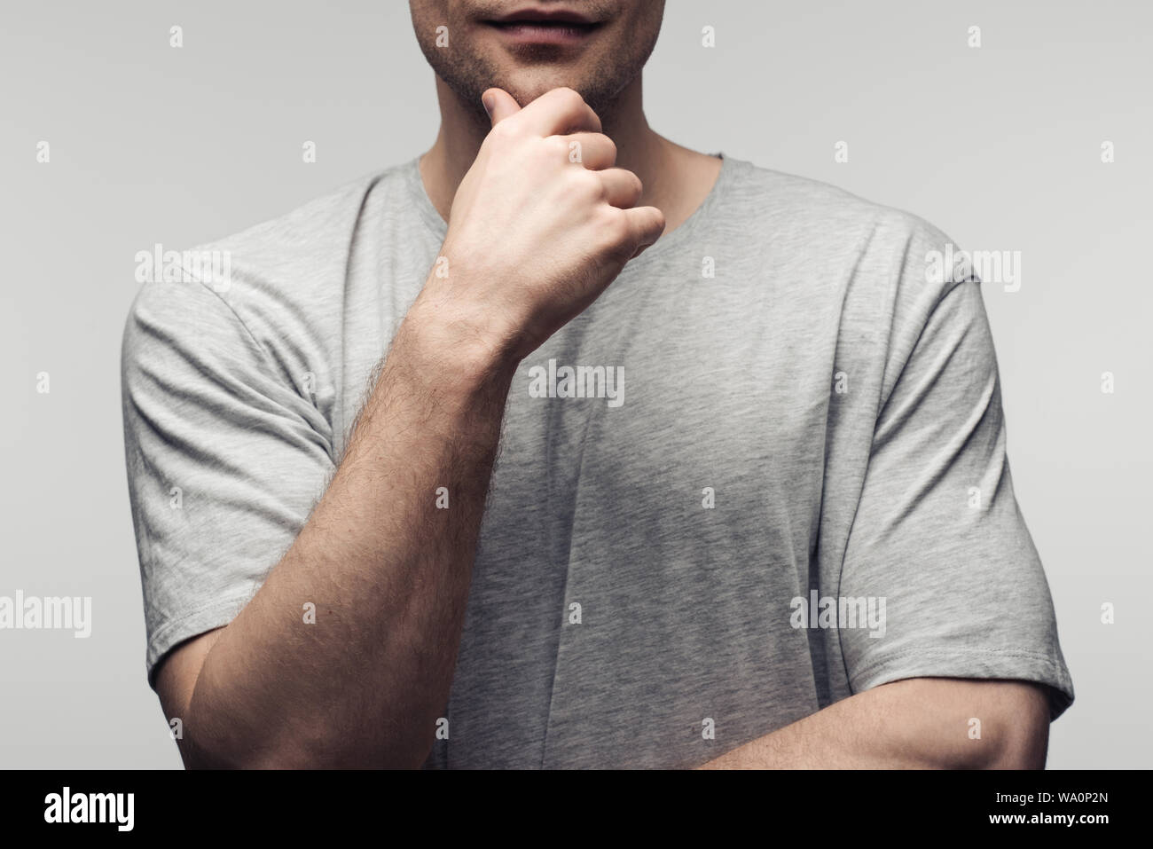 Vista parziale di azienda man mano vicino a faccia isolati su grigio, emozioni umane e concetto di espressione Foto Stock