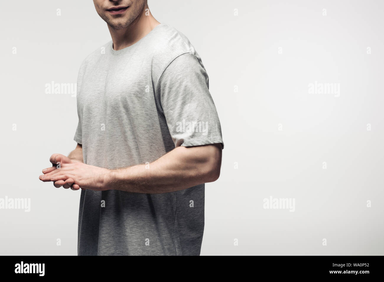 Vista ritagliata dell uomo con le mani giunte isolato su grigio, emozione umana e il concetto di espressione Foto Stock