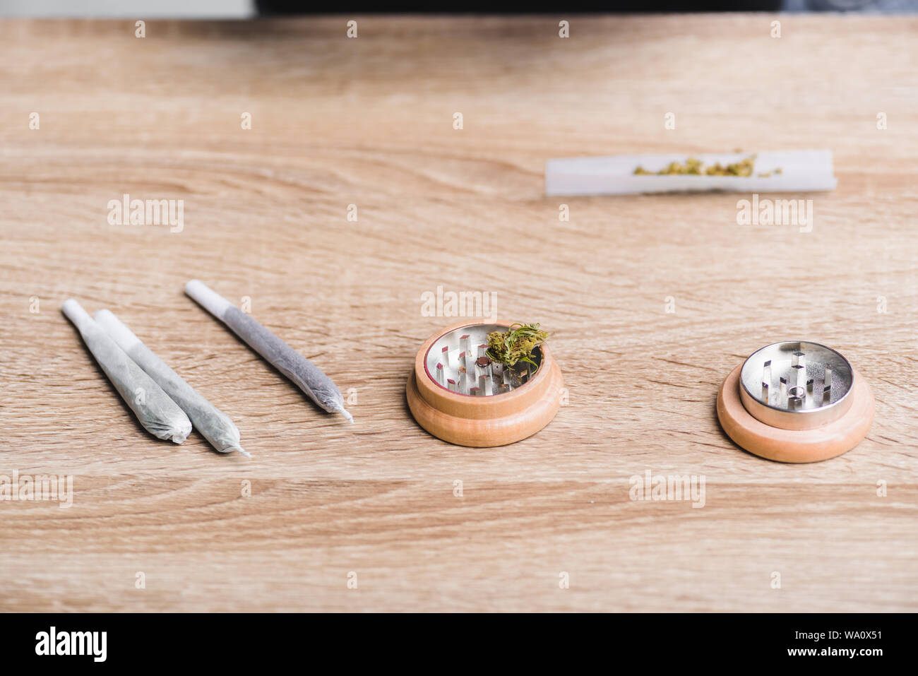 Giunti con la marijuana medica e herb grinder sul tavolo Foto Stock