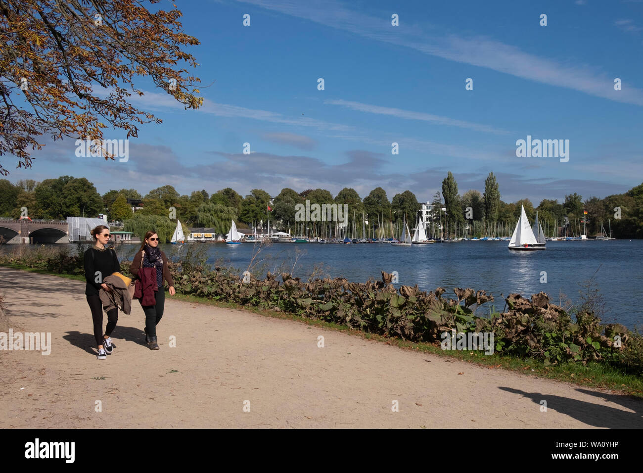 Le donne a piedi lungo esterno Lago Alster Amburgo, Germania Foto Stock