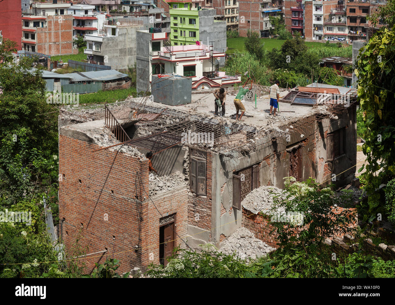 Gli uomini la riparazione di un edificio danneggiato dal terremoto di Kathmandu Foto Stock