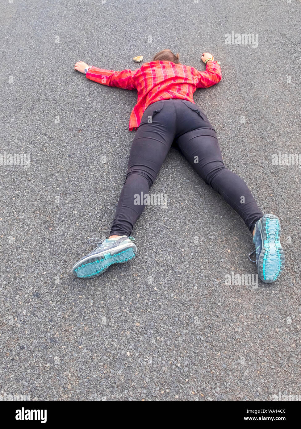 Donna sdraiata a faccia in giù di feriti su una strada Foto Stock