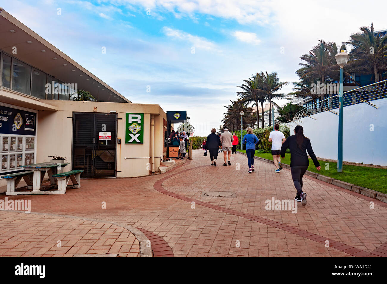 DURBAN, Sud Africa - 12 agosto 2019: turisti oltrepassando la Rox Coffee Shop sul lungomare presso la spiaggia di Umhlanga Rocks, vicino a Durban, KwaZul Foto Stock