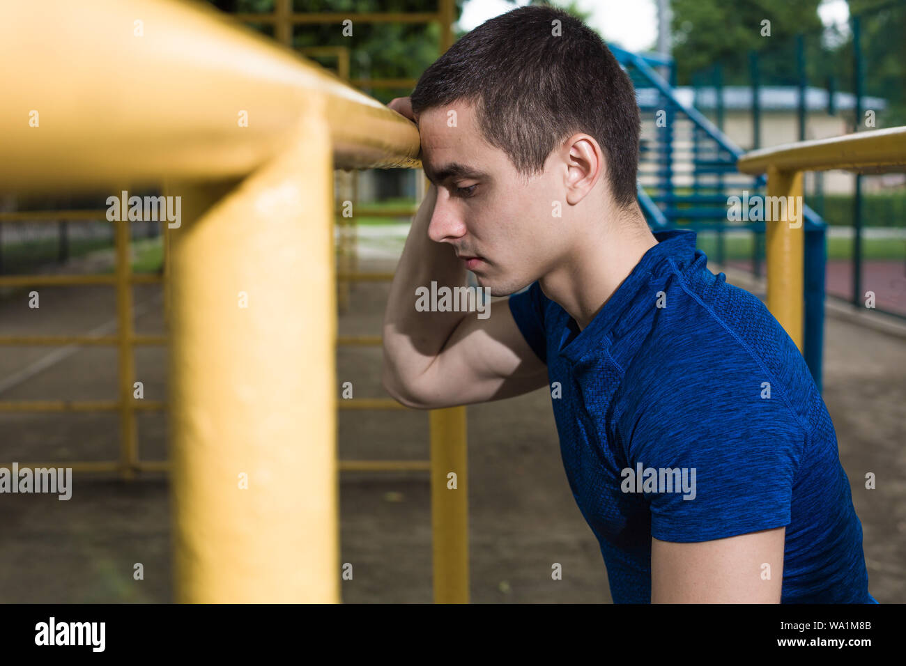 Un muscolo ragazzo caucasico in appoggio presso il campo sportivo Foto Stock
