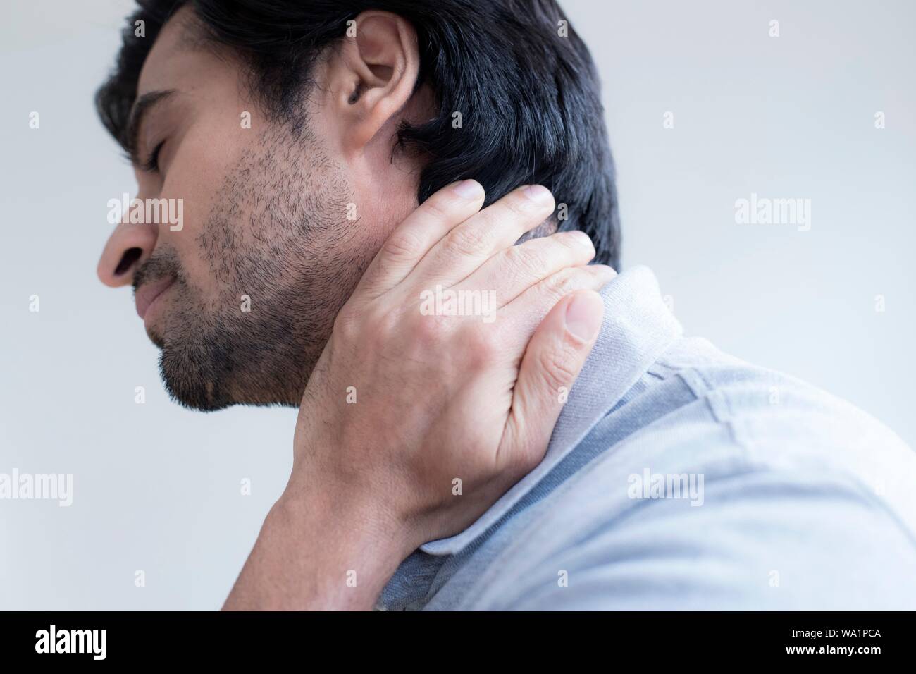 Uomo di toccare il suo collo nel dolore. Foto Stock