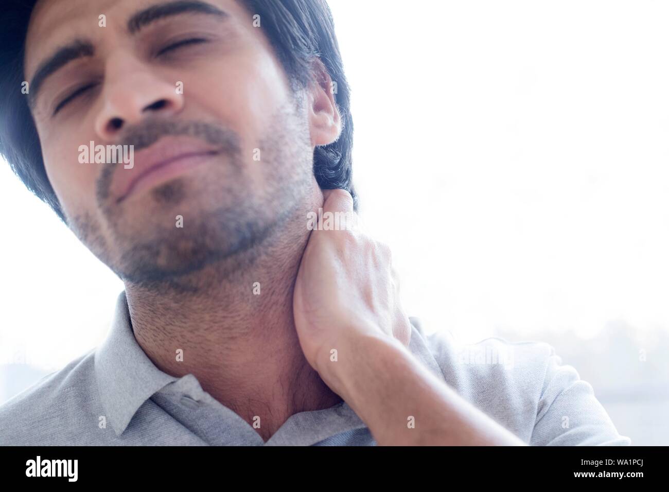 Uomo di toccare il suo collo nel dolore. Foto Stock