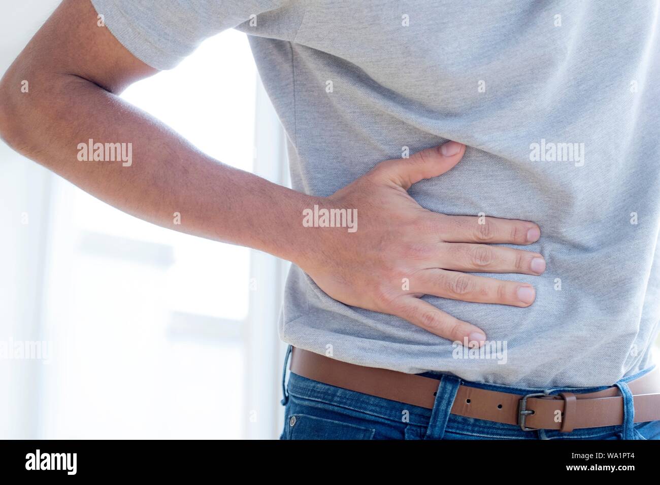 Uomo di toccare il suo stomaco nel dolore. Foto Stock