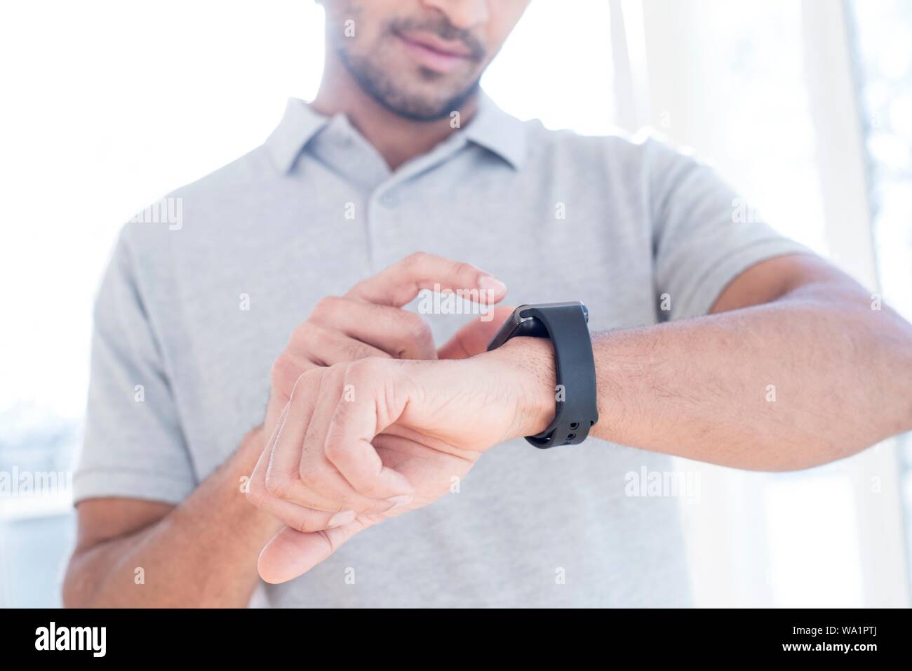 L'uomo controllando il suo orologio intelligente. Foto Stock