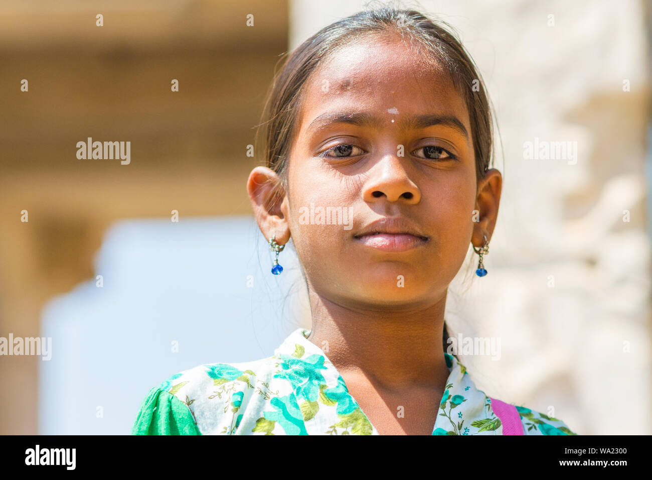 Hampi, Karnataka, India - 16 Febbraio 2015: una ragazza locale in blu orecchini pone per la videocamera all'esterno. Foto Stock