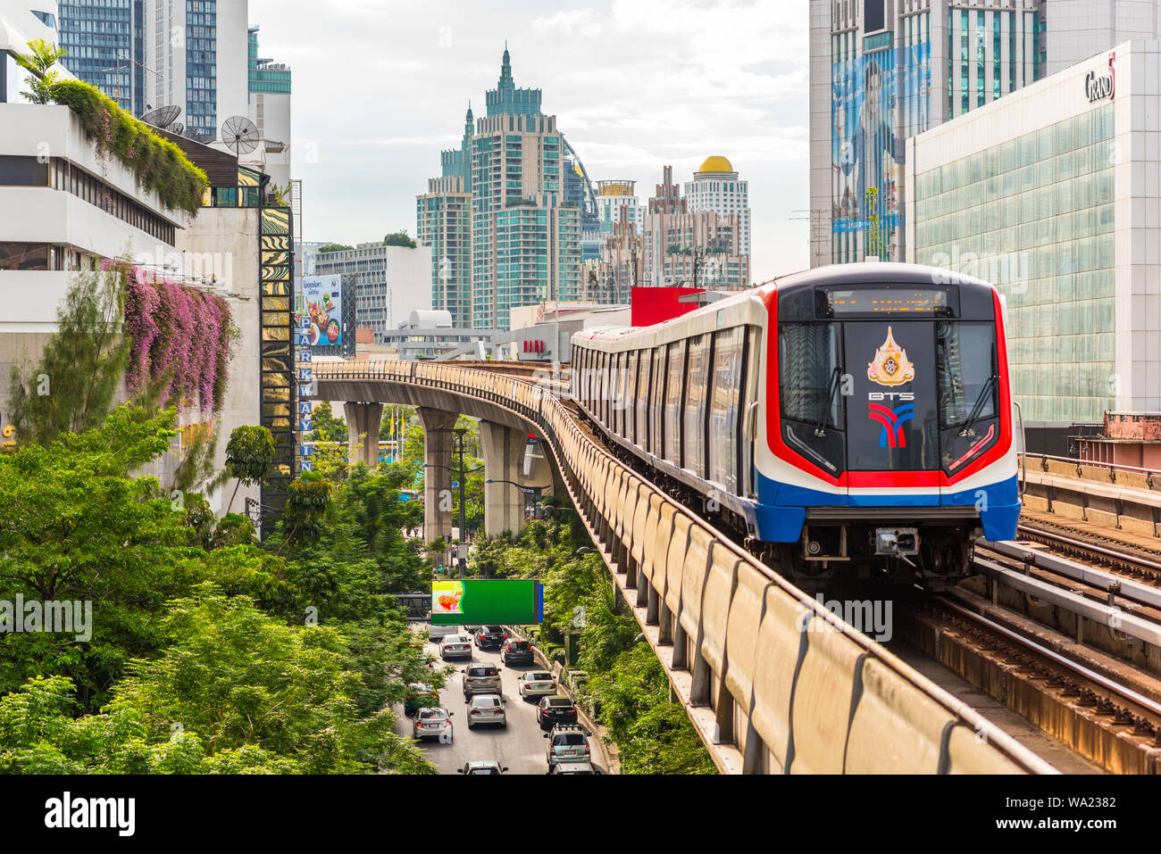 Bangkok - Giugno 25, 2019: un treno lascia Nana BTS Station, con una vista del centro cittadino di moderni edifici e Sukhumvit Road. Foto Stock