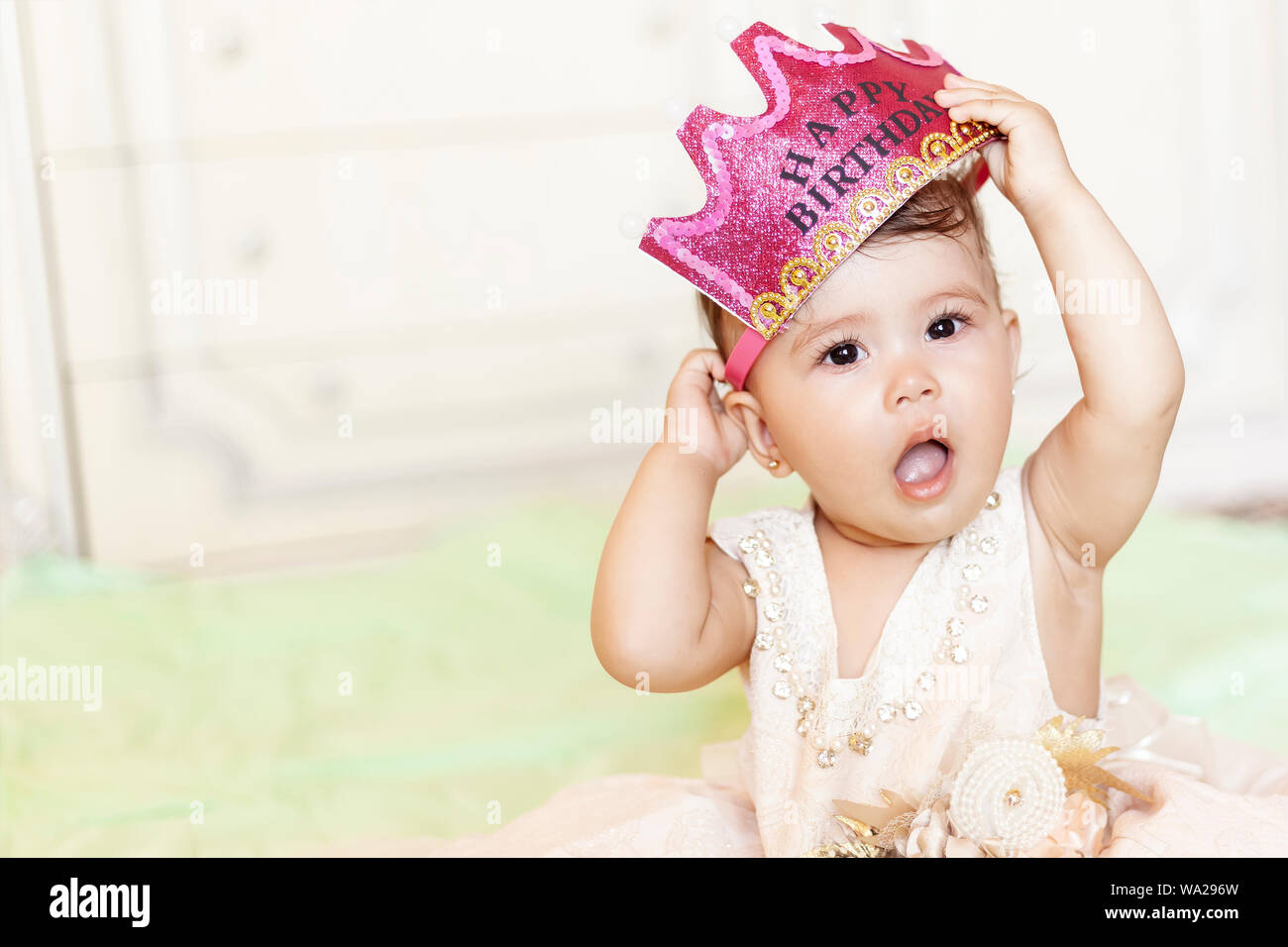 Primo compleanno. Poco allegra bambina con la corona festeggia il suo primo compleanno. Un divertente bambina vestita come una principessa Foto Stock