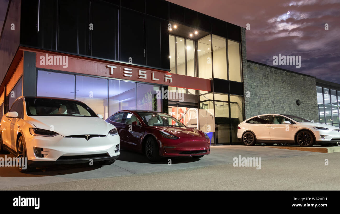 Ingresso della Tesla Showroom e Centro di Servizio con Tesla modello 3 e due Tesla Model X è parcheggiato di fronte. Foto Stock