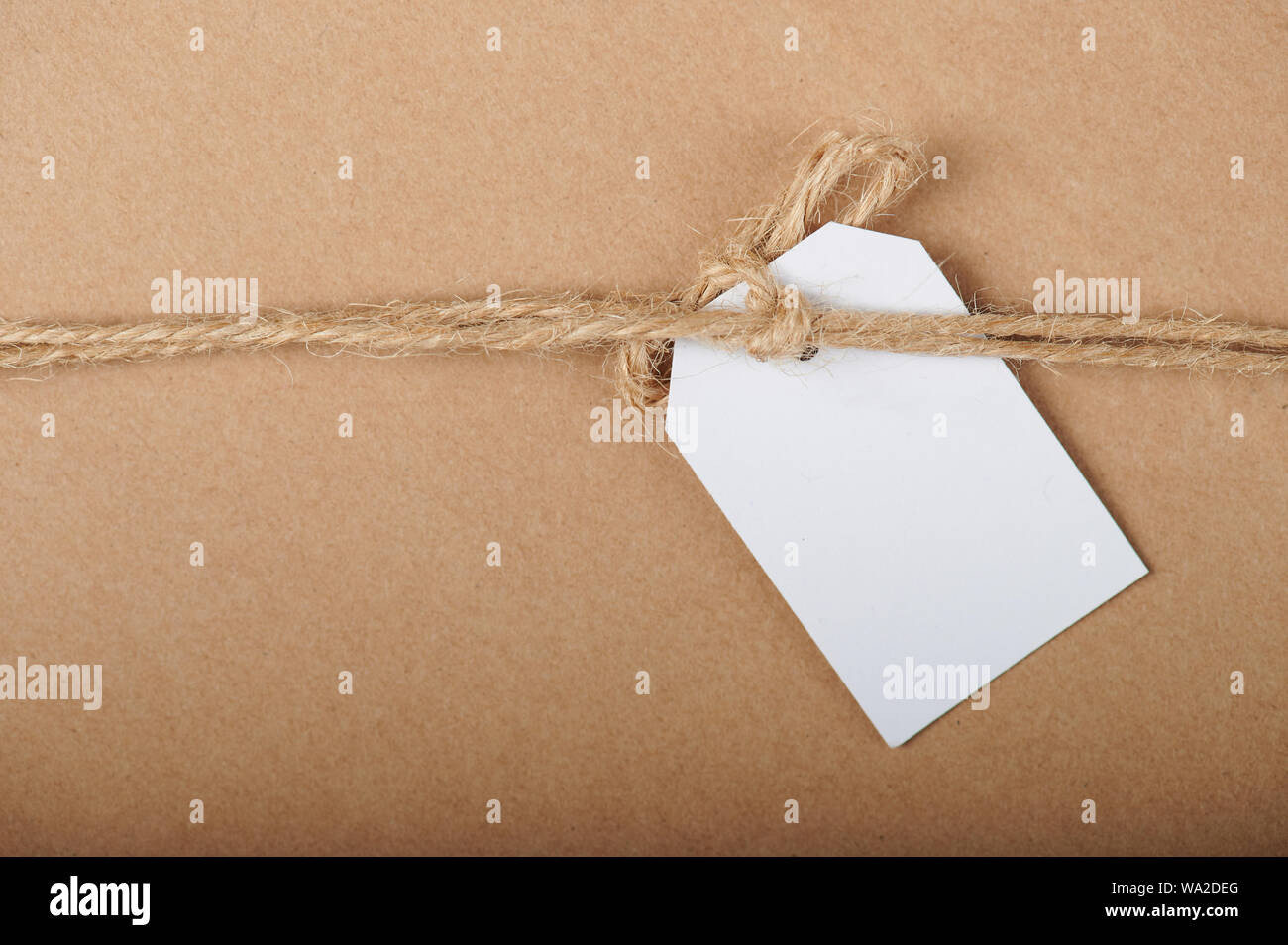 White paper tag regalo su marrone cartoon sfondo della carta Foto Stock