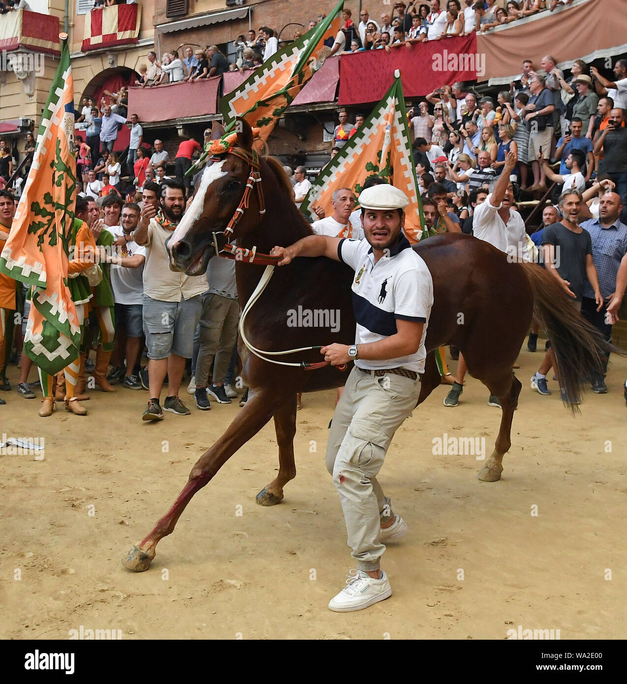 Siena, Italia. 16 Ago, 2019. Membri della 'Selva' (quartiere di foresta) celebrare dopo il loro cavallo Remorex ha vinto il cavallo di razza in palio senza la sua jockey in Siena, Italia, Agosto 16, 2019. La tradizionale corsa di cavalli Palio si tiene ogni mese di luglio e di agosto in italiano la storia della città di Siena. Credito: Alberto Lingria/Xinhua Foto Stock