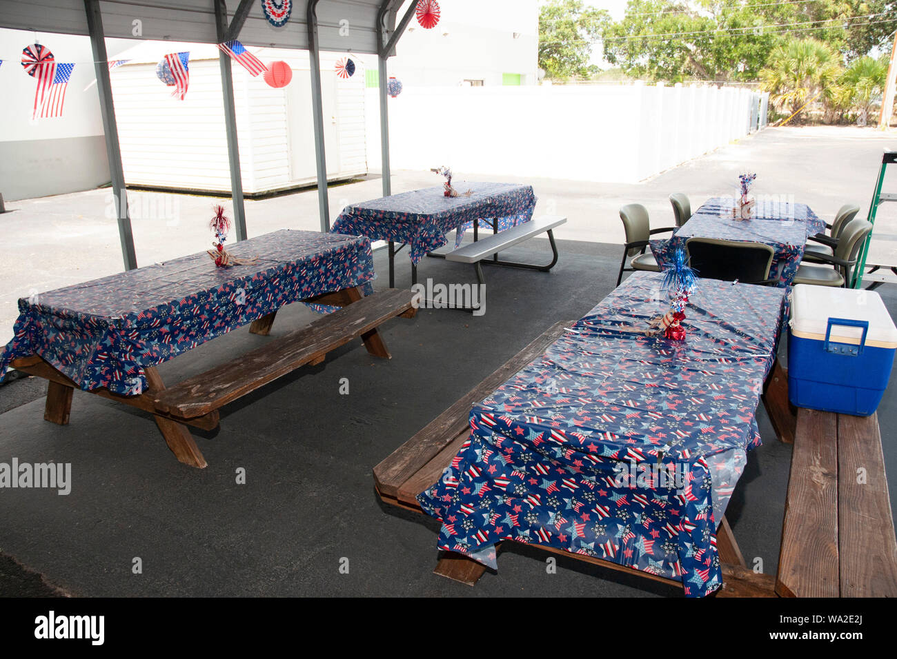 I tavoli da picnic sono impostati per il giorno di indipendenza il barbecue presso l'ufficio con decorazioni di festa. Ci sono un sacco di rosso bianco e blu sul tavolo. Foto Stock