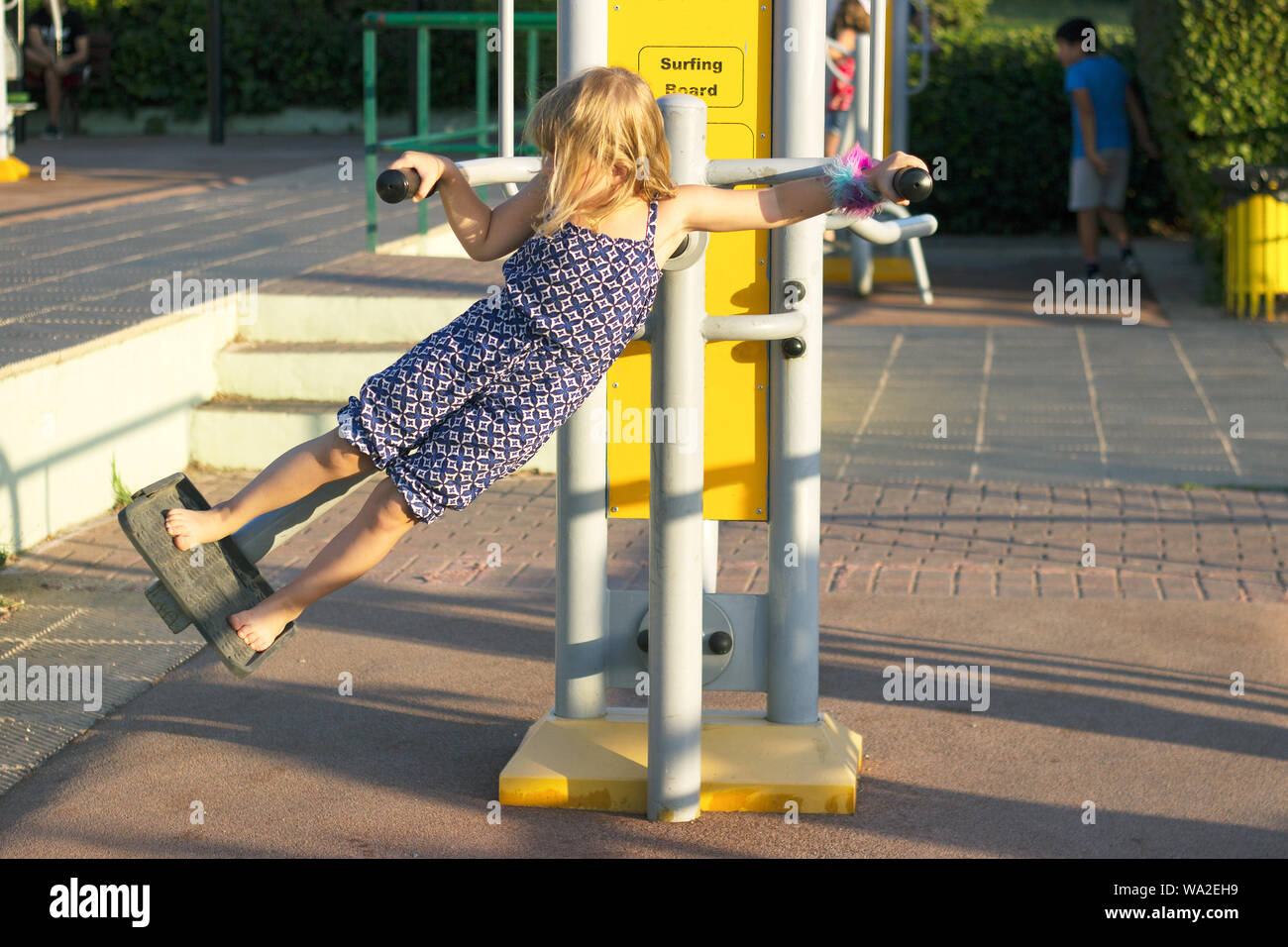 Bambina sta facendo surf board esercizio in palestra all'aperto Foto Stock