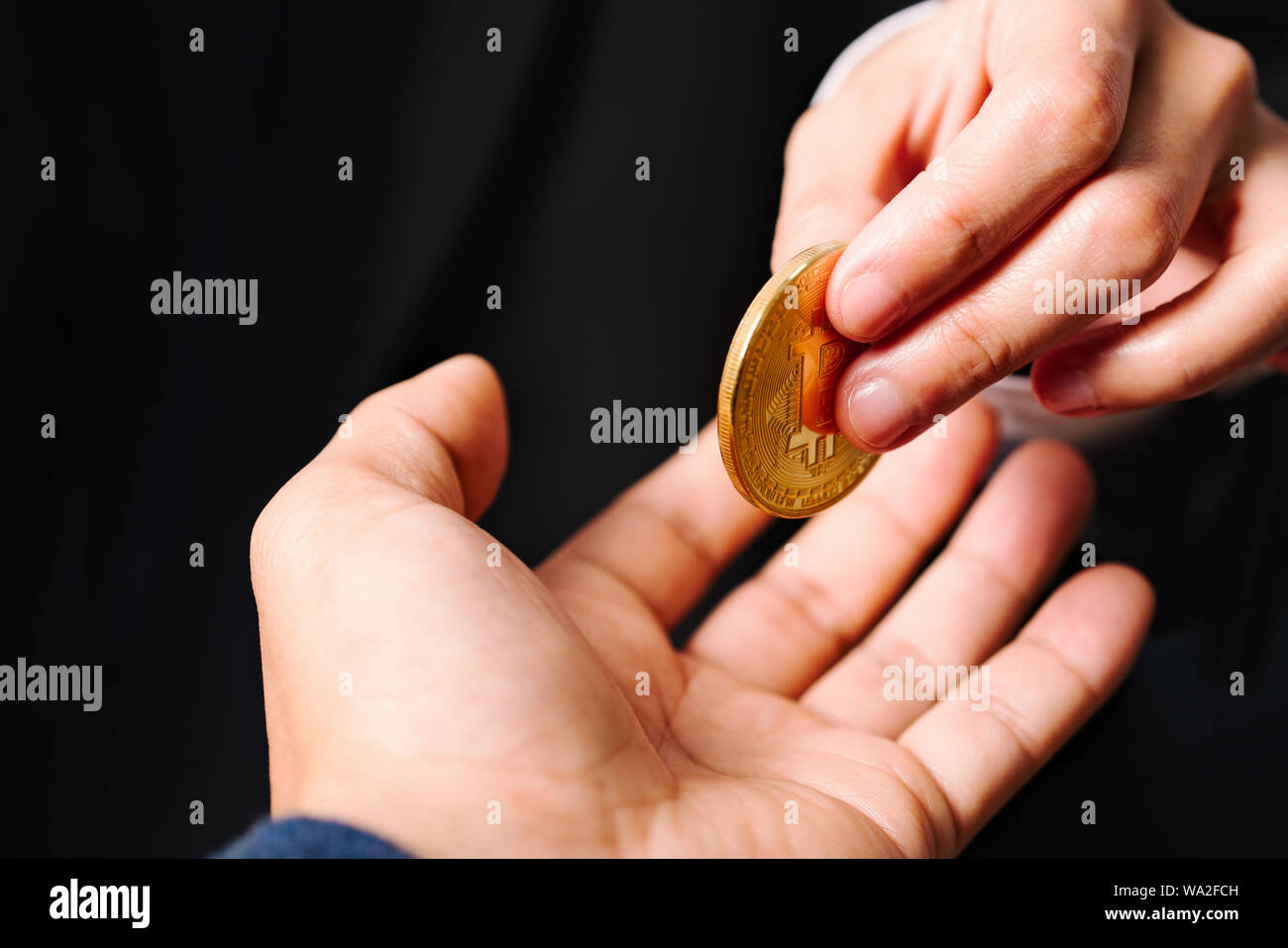 Monete cryptocurrency Bitcoin, donne tenere premuto il bottone cryptocurrency sulla mano. Lo scambio di denaro Foto Stock
