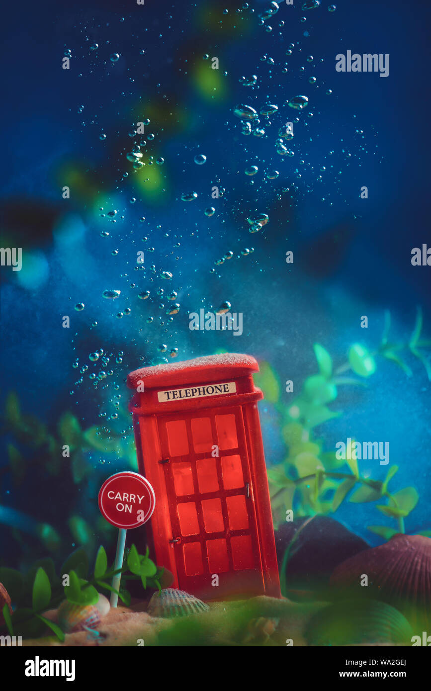Rosso inglese cabina telefonica sott'acqua. Il riscaldamento globale del concetto. Concettuale vita ancora con miniature. Foto Stock