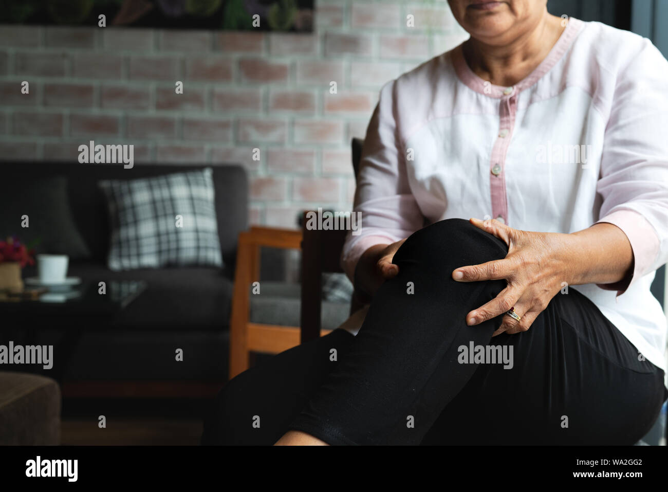 Senior donna che soffrono di dolore al ginocchio a casa, il problema della salute concetto Foto Stock