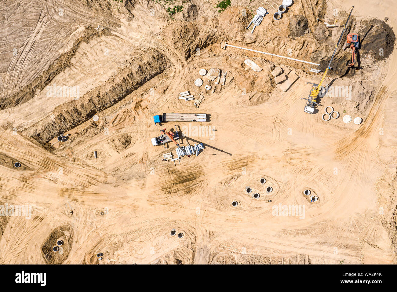 Gruppo di macchine industriali installazione sistema di drenaggio delle acque al sito in costruzione. drone immagine Foto Stock